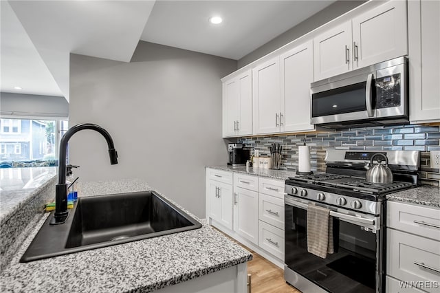 184 14th St, Buffalo, NY 14213 - kitchen with stainless steel appliances, decorative backsplash, white cabinetry, light stone countertops, and recessed lighting