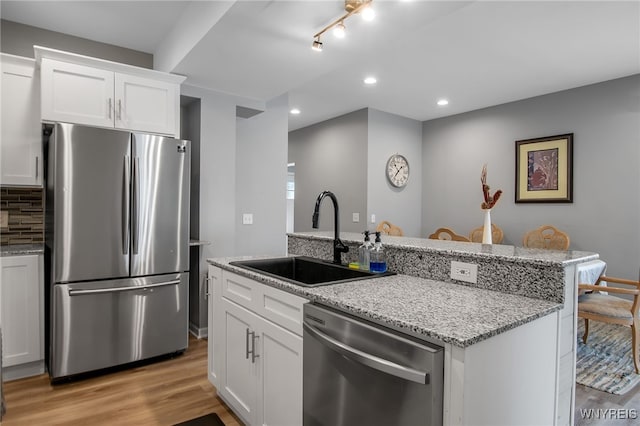 184 14th St, Buffalo, NY 14213 - kitchen featuring stainless steel appliances, a kitchen island with sink, recessed lighting, light wood-style floors, and backsplash
