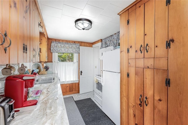 8479 Princeton St, Richmond, NY 14471 - kitchen featuring freestanding refrigerator, light countertops, brown cabinets, stove, and wood walls