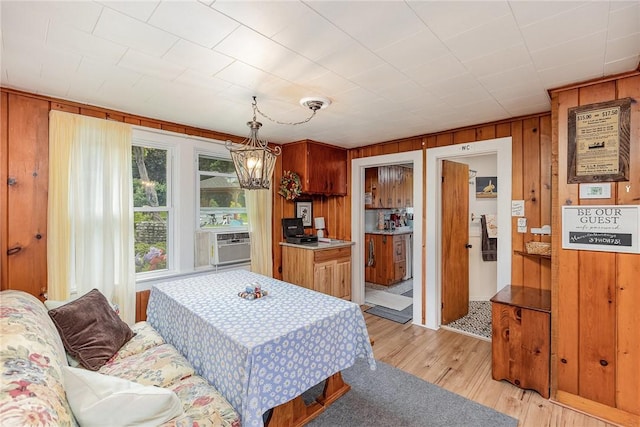 8479 Princeton St, Richmond, NY 14471 - dining area with wooden walls, light wood-style flooring, a chandelier, and cooling unit