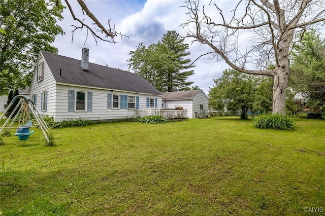 703 Winchester Rd, Dewitt, NY 13057 - rear view of house with a chimney, a yard, a shingled roof, a wooden deck, and a playground