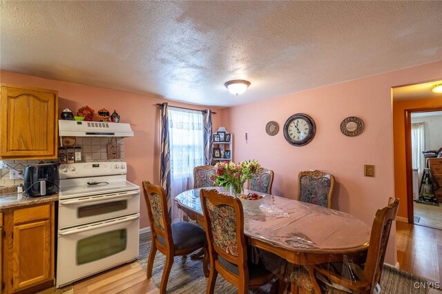 703 Winchester Rd, Dewitt, NY 13057 - dining room featuring light wood finished floors and a textured ceiling