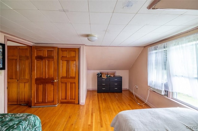 703 Winchester Rd, Dewitt, NY 13057 - bedroom featuring multiple windows, light wood-type flooring, and lofted ceiling