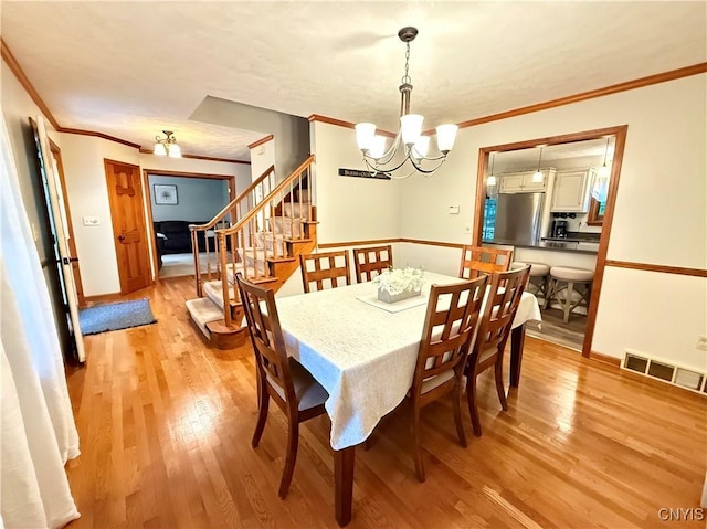 550 Sayles St, Oneida-Inside, NY 13421 - dining room featuring a chandelier, ornamental molding, light wood-style flooring, and stairway