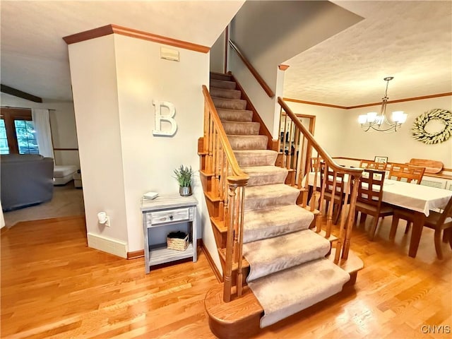 550 Sayles St, Oneida-Inside, NY 13421 - stairs with wood finished floors, crown molding, and a chandelier