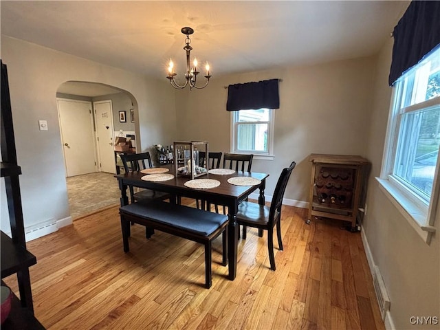 301 Loma Ave, Syracuse, NY 13208 - dining area featuring arched walkways, a chandelier, and light wood finished floors
