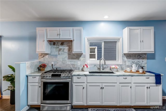 66 Cochrane St, Buffalo, NY 14206 - kitchen with stainless steel gas range oven, white cabinets, tasteful backsplash, and light countertops