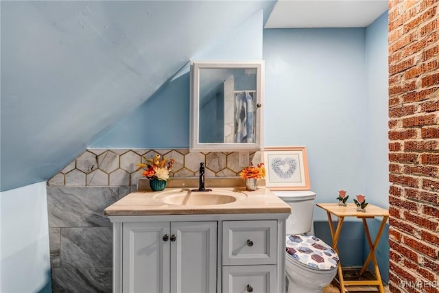 66 Cochrane St, Buffalo, NY 14206 - bathroom featuring vanity, lofted ceiling, and brick wall