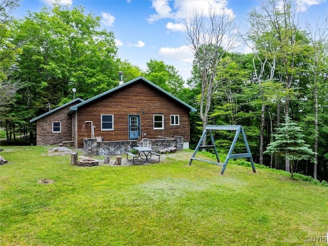 146 Mohawk Dr W, Webb, NY 13420 - back of property with a lawn, an outdoor fire pit, and stone siding