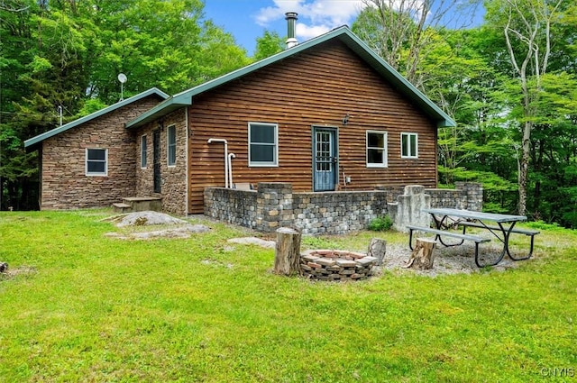 146 Mohawk Dr W, Webb, NY 13420 - rear view of property featuring a fire pit, a yard, and stone siding