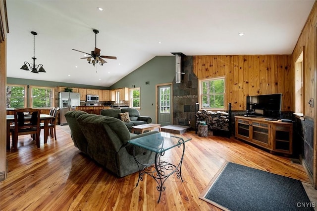 146 Mohawk Dr W, Webb, NY 13420 - living room featuring light wood-style floors, vaulted ceiling, a ceiling fan, and wood walls