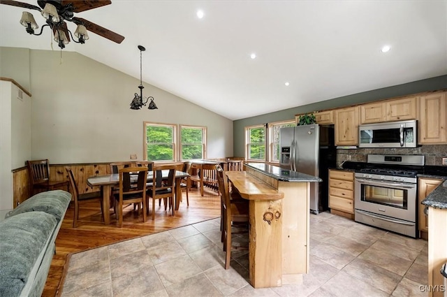146 Mohawk Dr W, Webb, NY 13420 - kitchen with appliances with stainless steel finishes, ceiling fan, vaulted ceiling, light brown cabinetry, and a center island