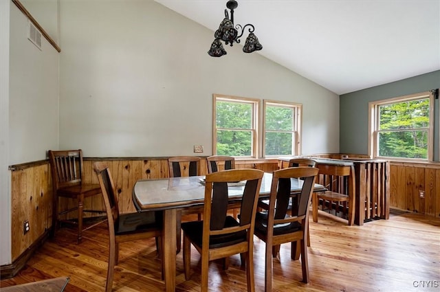 146 Mohawk Dr W, Webb, NY 13420 - dining area featuring light wood-style floors, wainscoting, wooden walls, and high vaulted ceiling