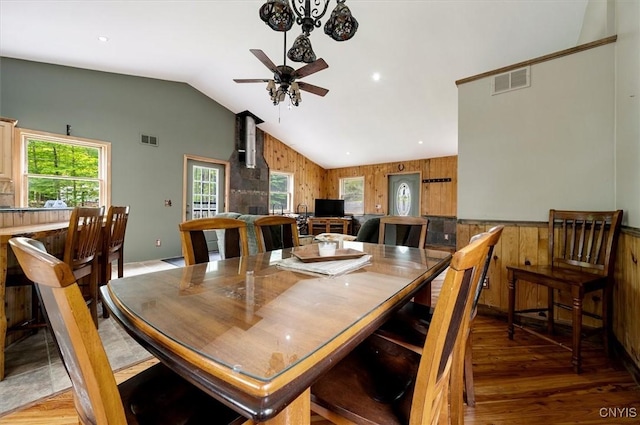 146 Mohawk Dr W, Webb, NY 13420 - dining area featuring lofted ceiling, wooden walls, a ceiling fan, and light wood-type flooring