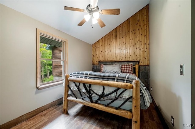 146 Mohawk Dr W, Webb, NY 13420 - bedroom featuring vaulted ceiling, wooden walls, wood finished floors, and ceiling fan