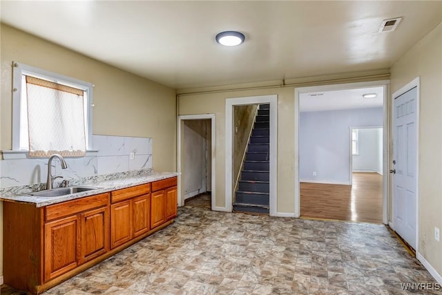86 Deshler St, Buffalo, NY 14212 - kitchen featuring brown cabinetry, decorative backsplash, and light stone counters