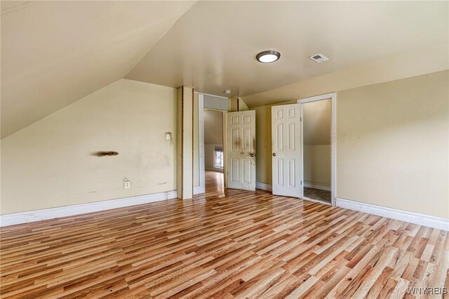 86 Deshler St, Buffalo, NY 14212 - unfurnished bedroom with light wood finished floors, lofted ceiling, and a closet