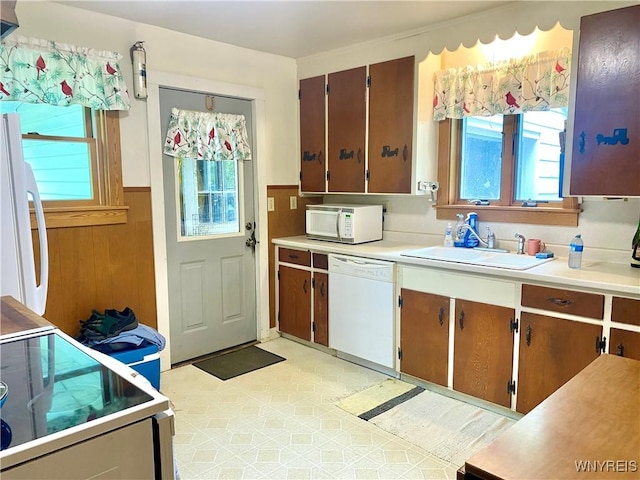 11671 Gowanda State Rd, North Collins, NY 14111 - kitchen with white appliances, healthy amount of natural light, light countertops, a wainscoted wall, and wooden walls