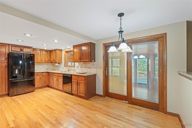 8013 Ginger Rd, Clay, NY 13090 - kitchen featuring black appliances, light wood-style flooring, backsplash, light countertops, and hanging light fixtures