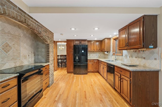 8013 Ginger Rd, Clay, NY 13090 - kitchen featuring black appliances, light wood-type flooring, tasteful backsplash, light stone counters, and a chandelier