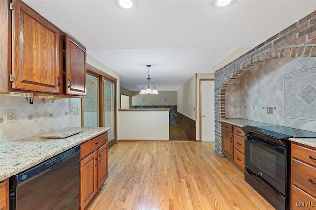 8013 Ginger Rd, Clay, NY 13090 - kitchen with black appliances, tasteful backsplash, brown cabinetry, light wood-type flooring, and light stone countertops