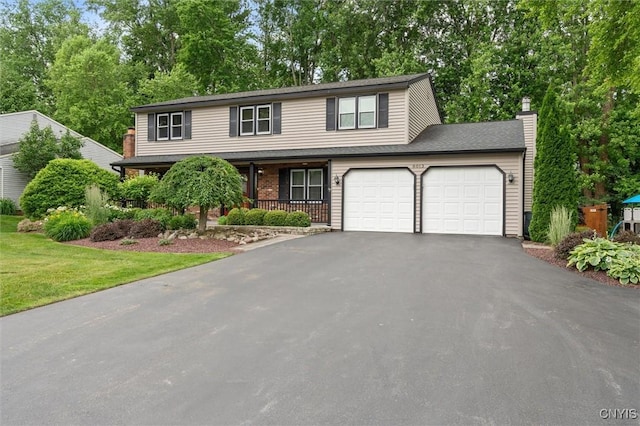 8013 Ginger Rd, Clay, NY 13090 - view of front facade featuring asphalt driveway, a porch, an attached garage, a chimney, and view of wooded area