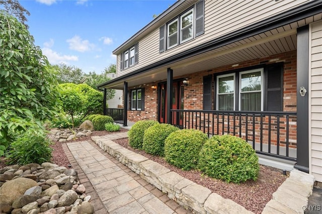 8013 Ginger Rd, Clay, NY 13090 - view of exterior entry featuring brick siding and a porch