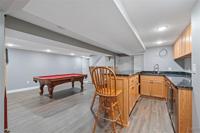 8013 Ginger Rd, Clay, NY 13090 - kitchen featuring light wood-style floors, a breakfast bar area, a peninsula, a textured ceiling, and billiards