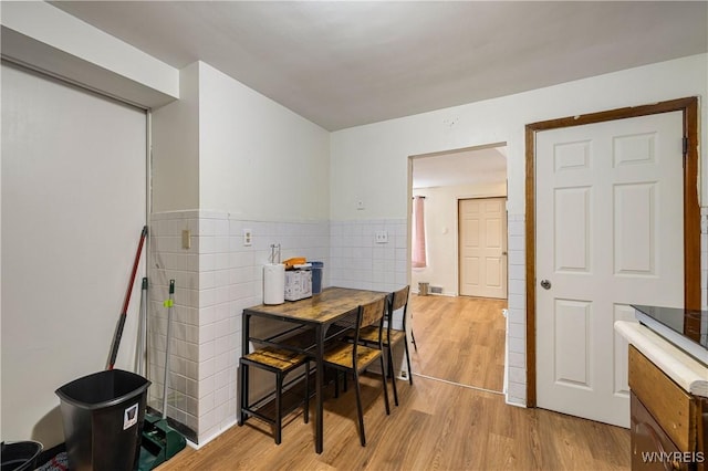 1004 19th St, Niagara Falls, NY 14301 - dining area with light wood-type flooring, tile walls, and wainscoting