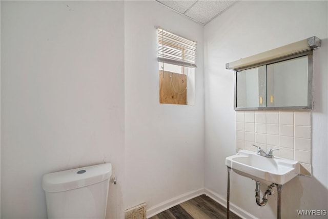 2511 Pine Ave, Niagara Falls, NY 14301 - half bathroom featuring tasteful backsplash, wood finished floors, and a paneled ceiling