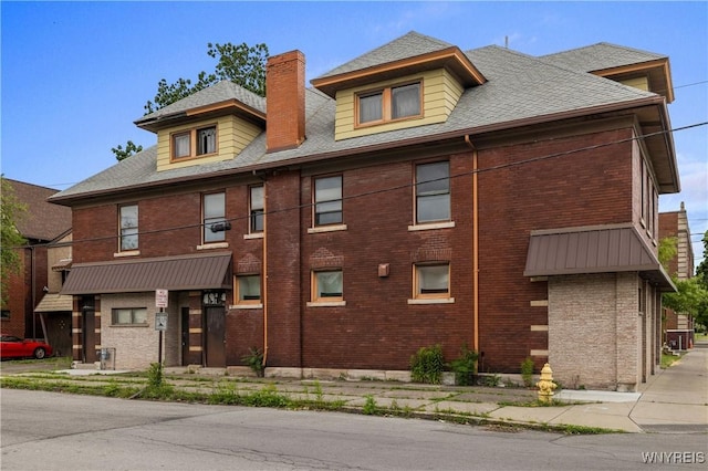 700 Pine Ave, Niagara Falls, NY 14301 - view of front of property with brick siding, a chimney, and roof with shingles