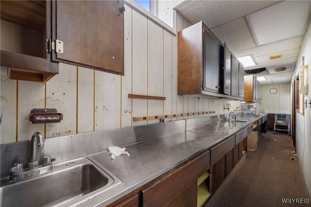 700 Pine Ave, Niagara Falls, NY 14301 - kitchen with stainless steel countertops, wooden walls, a drop ceiling, and dark carpet