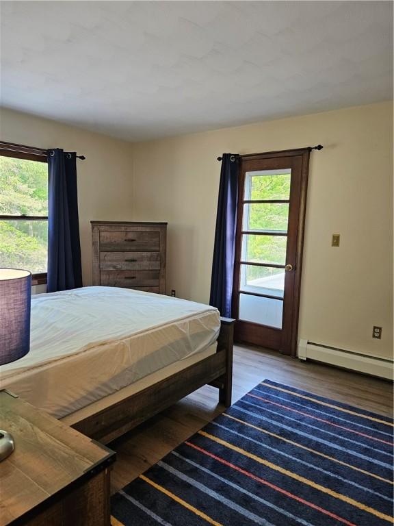 818 Larchmont Cir, Elmira, NY 14905 - bedroom with baseboard heating, multiple windows, and wood finished floors