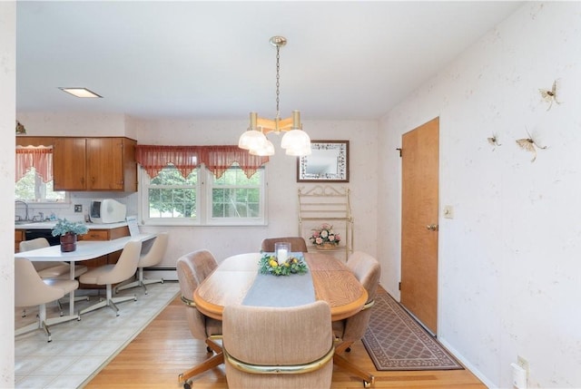 6 Meadowbrook Ter, North Dansville, NY 14437 - dining space with a baseboard heating unit, a chandelier, and light wood-style flooring