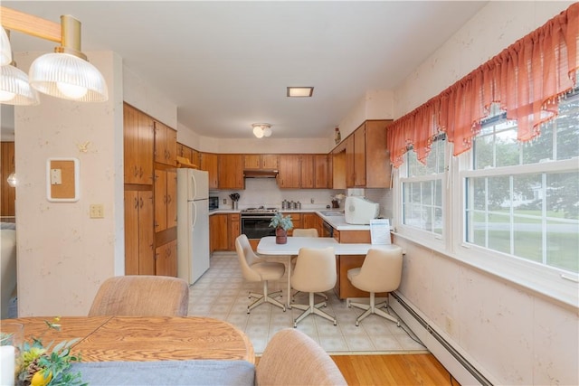 6 Meadowbrook Ter, North Dansville, NY 14437 - kitchen featuring freestanding refrigerator, stainless steel stove, light countertops, baseboard heating, and brown cabinets