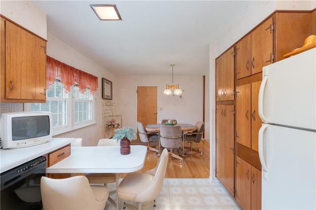 6 Meadowbrook Ter, North Dansville, NY 14437 - kitchen featuring freestanding refrigerator, dishwasher, a chandelier, and brown cabinetry