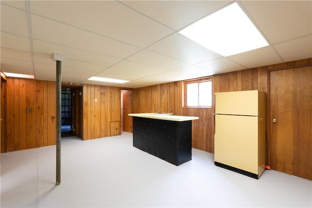 6 Meadowbrook Ter, North Dansville, NY 14437 - basement with freestanding refrigerator, a drop ceiling, and wooden walls