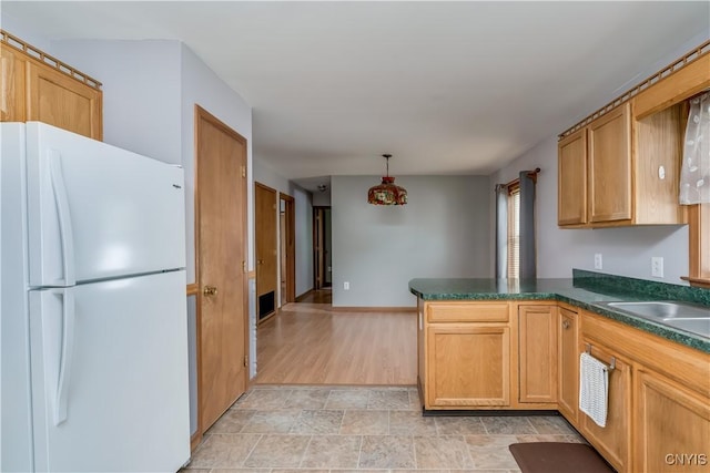 60 Van Buren St, Antwerp, NY 13608 - kitchen featuring freestanding refrigerator, dark countertops, a peninsula, decorative light fixtures, and stone finish flooring