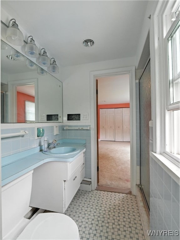71 Saratoga Rd, Amherst, NY 14226 - full bathroom featuring vanity, healthy amount of natural light, tile walls, and a stall shower