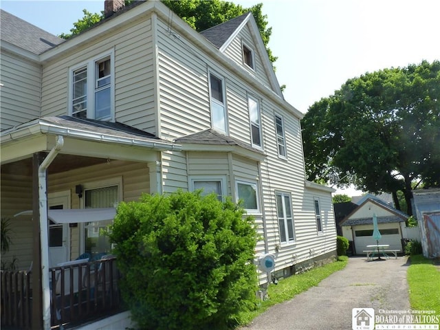174 Bowen St, Jamestown, NY 14701 - view of side of property featuring an outdoor structure, roof with shingles, a chimney, and a garage