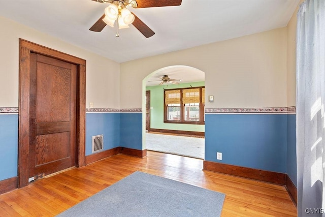 217 Mackay Ave, Camillus, NY 13219 - unfurnished room featuring arched walkways, ceiling fan, and wood finished floors