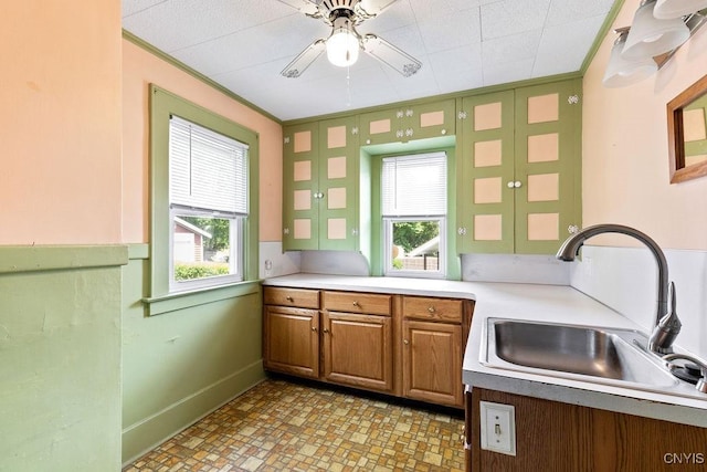 217 Mackay Ave, Camillus, NY 13219 - kitchen with crown molding, ceiling fan, brown cabinetry, and light countertops