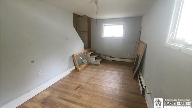 4010 Main St, Scio, NY 14880 - unfurnished room with a baseboard radiator, wood-type flooring, and stairs
