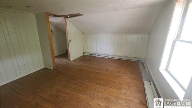 4010 Main St, Scio, NY 14880 - additional living space with vaulted ceiling, hardwood / wood-style flooring, wood walls, baseboard heating, and a baseboard radiator
