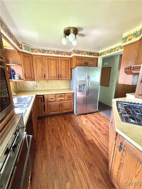 6473 Wembridge Dr, Dewitt, NY 13057 - kitchen with appliances with stainless steel finishes, light countertops, dark wood-type flooring, and brown cabinets