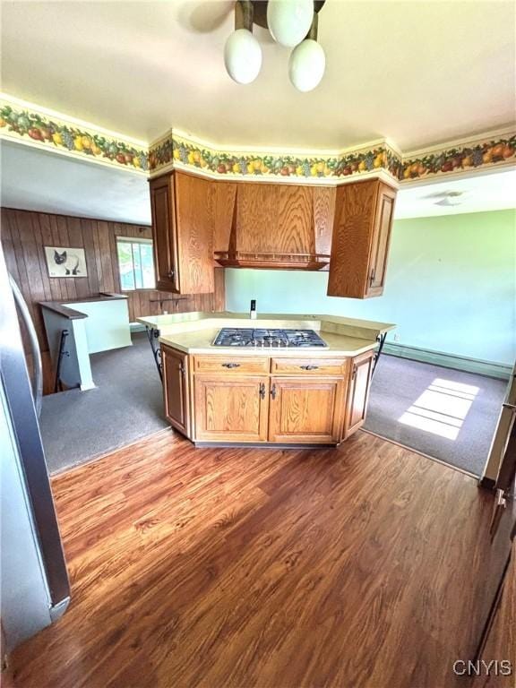6473 Wembridge Dr, Dewitt, NY 13057 - kitchen with appliances with stainless steel finishes, premium range hood, light countertops, wood finished floors, and wood walls