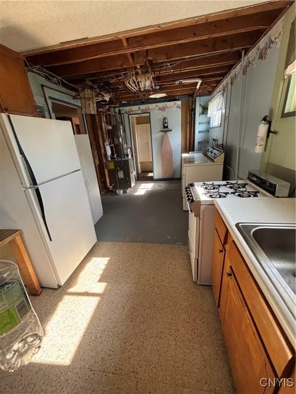 6473 Wembridge Dr, Dewitt, NY 13057 - kitchen with white appliances, washer and clothes dryer, brown cabinets, and light countertops