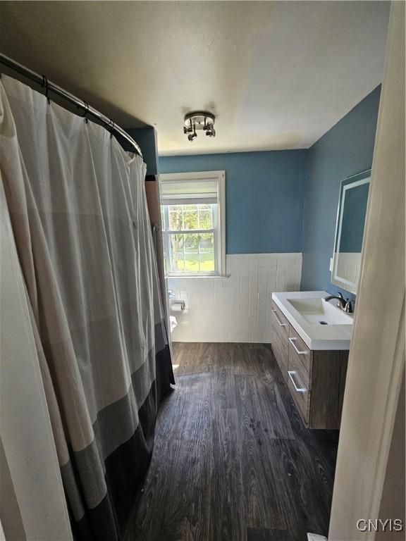 203 Windemere Rd, Geddes, NY 13219 - bathroom featuring wood finished floors, wainscoting, vanity, and a shower with shower curtain