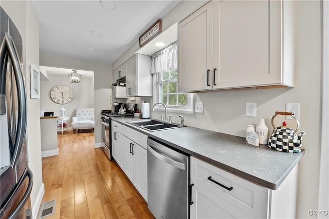 150 E Hawthorne Way, Sullivan, NY 13037 - kitchen with appliances with stainless steel finishes, light wood finished floors, white cabinetry, dark countertops, and a chandelier