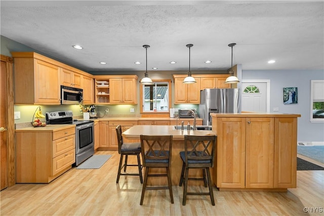 10327 Wolcott Hill Rd, Camden, NY 13316 - kitchen featuring appliances with stainless steel finishes, light wood finished floors, light brown cabinetry, light countertops, and a kitchen bar